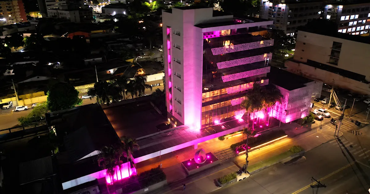 Prédio iluminado de rosa à noite em apoio ao Outubro Rosa